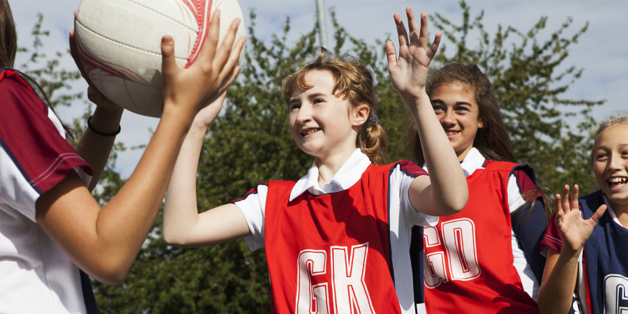 Schoolgirl netball players defending