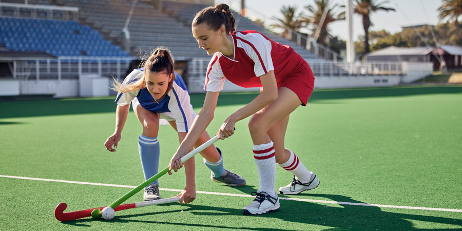 Sports fitness field hockey game and women challenge for ball in stadium competition